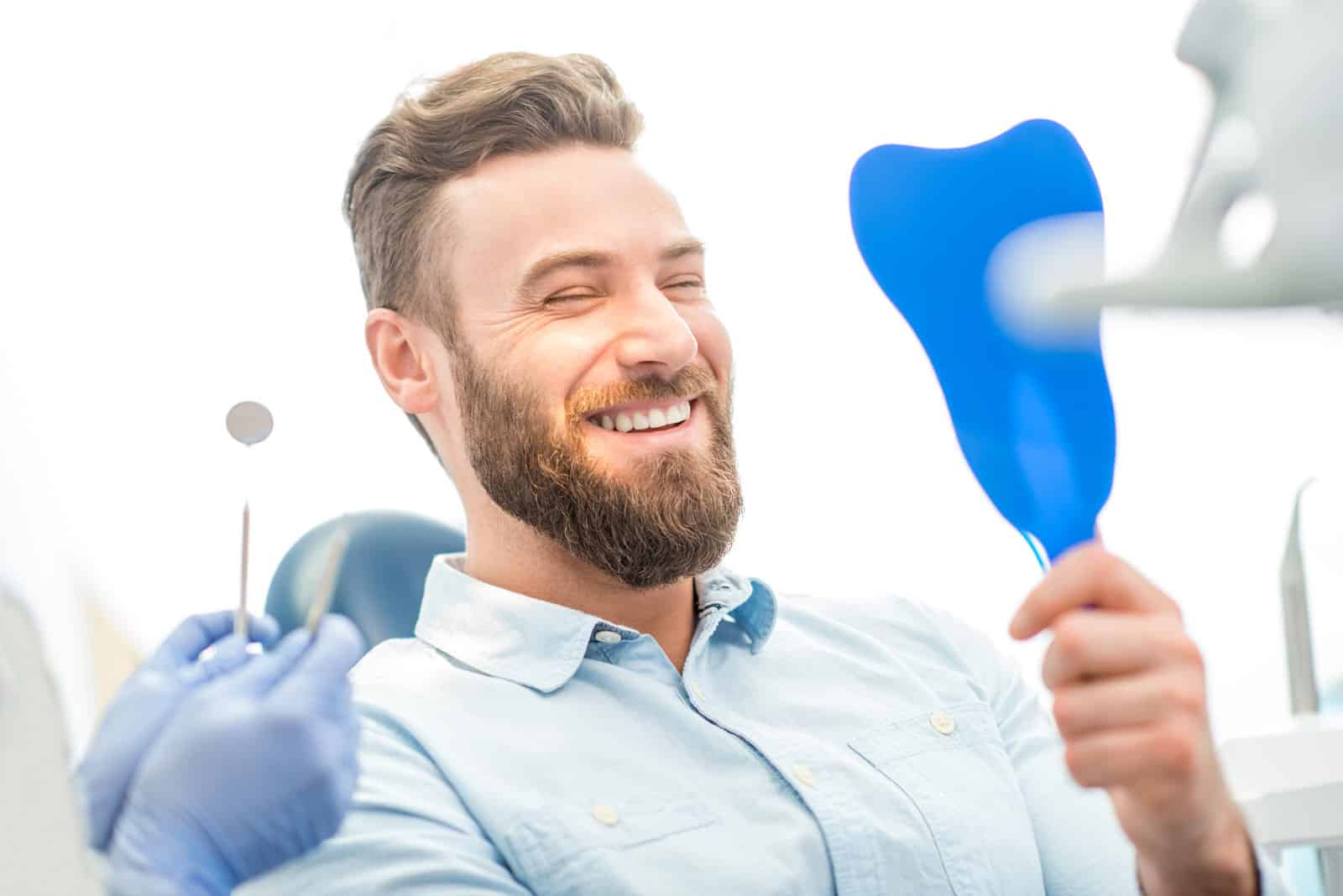 A man smiles contentedly in a dentist chair, highlighting a positive and comfortable dental experience