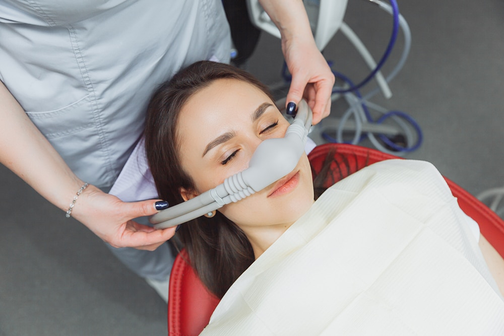 A woman lying comfortably in a dental chair after receiving sedation dentistry, ensuring a calm and stress-free procedure