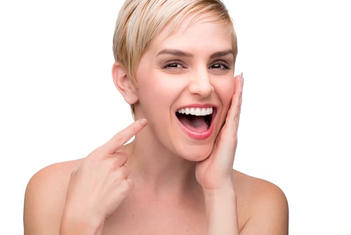 A woman displays her teeth with an open mouth and a pointing gesture, emphasizing the role of equilibration in dentistry