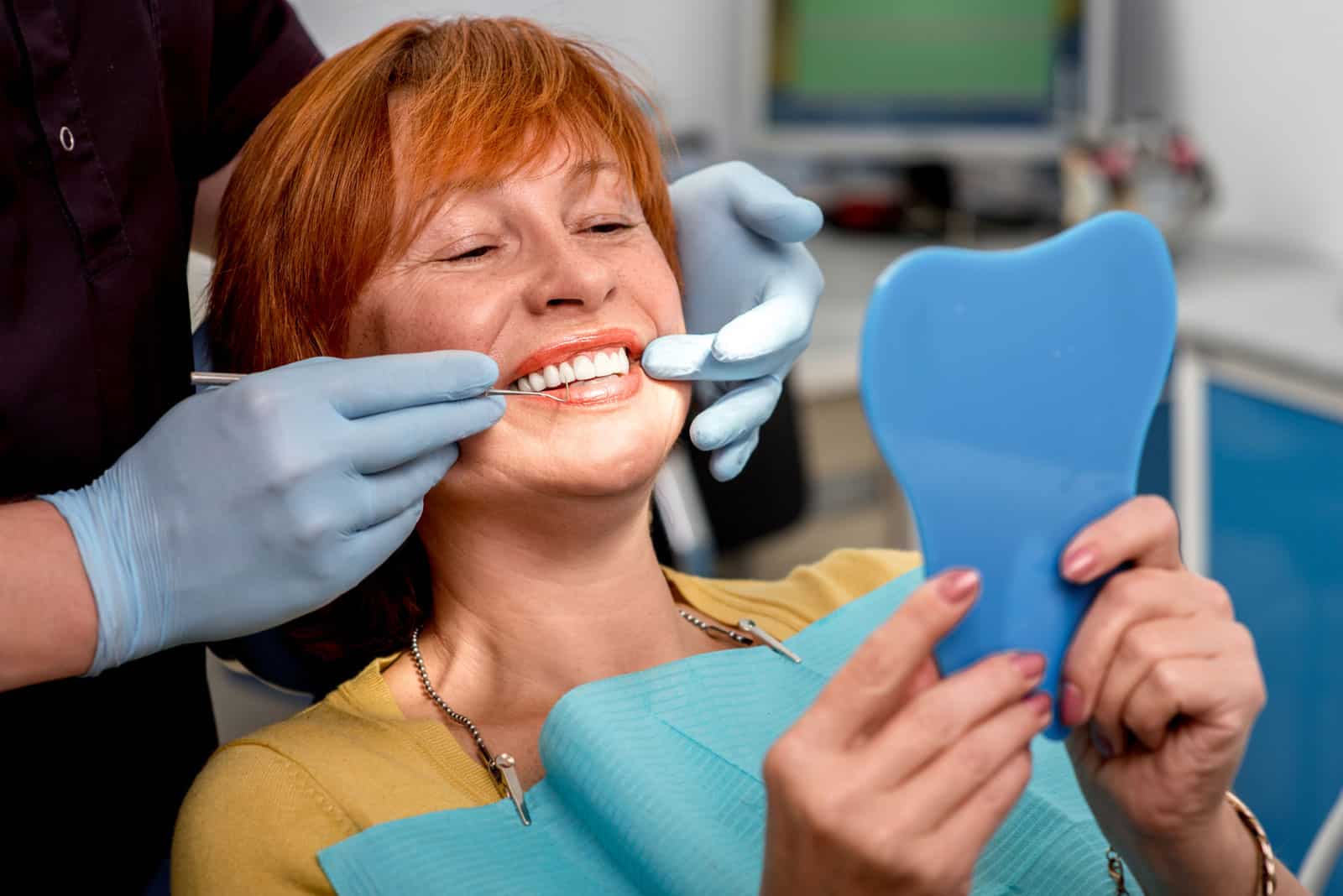 A woman undergoing a dental cleaning procedure as part of her full mouth reconstruction at the dentist's office